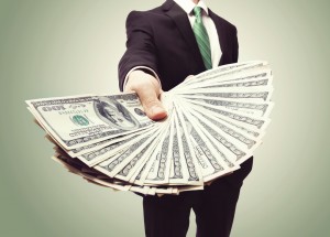 An image of a Business Man Displaying a Spread of Cash over a green vintage background